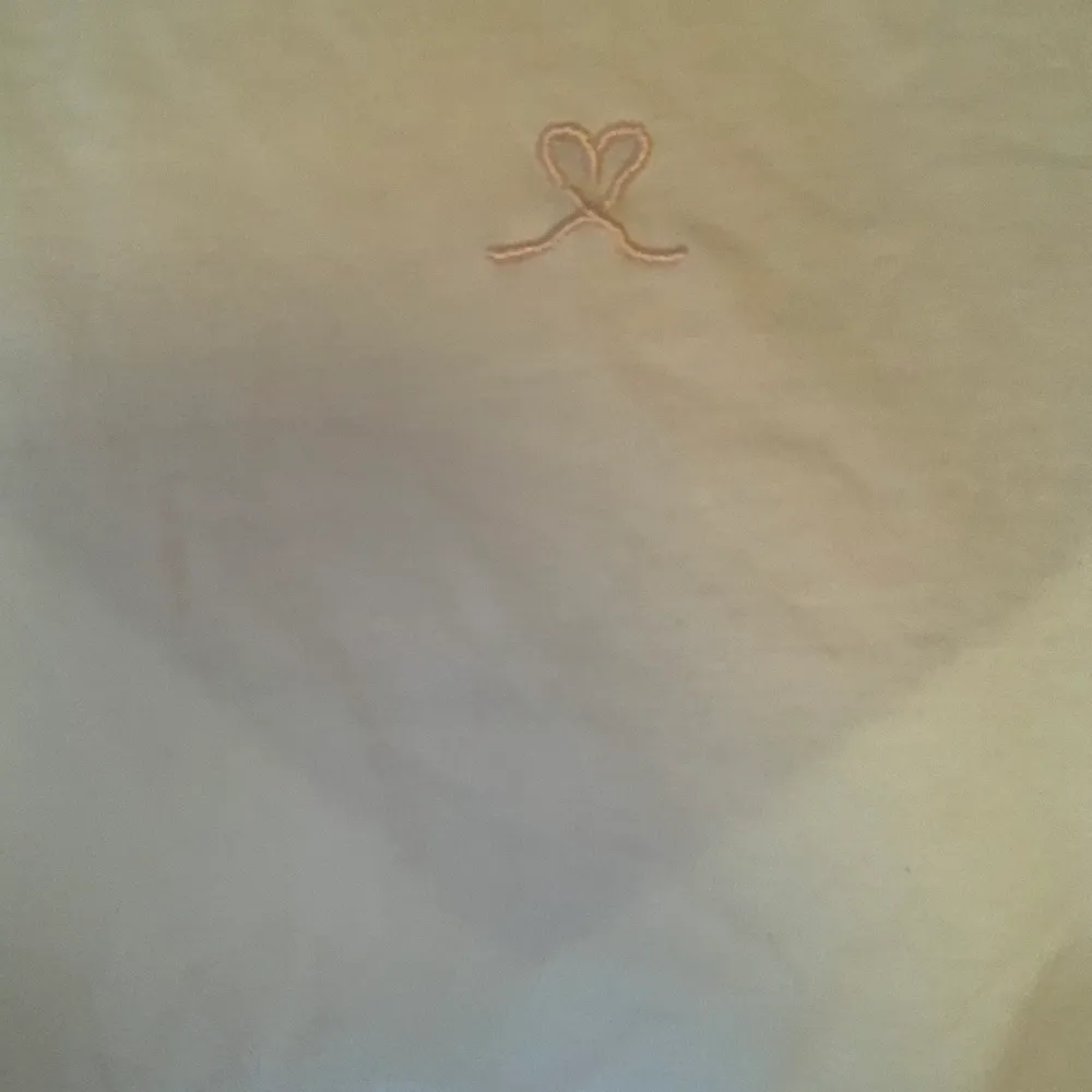 En creme vit t shirt i storlek XS med en broderad rosa gullig hjärt detalj från divided 💗 har inga fläckar eller hål😻 frakt på 22kr tillkommer 😘. T-shirts.