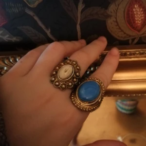 Stora ringar - Ringar med guld ramar och stenar i blått och kräm. 💍💜 50kr st eller 110 för båda inkl frakt😇