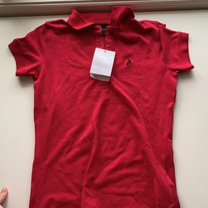 NY Peak performance piké  - Säljer min helt oanvända peak piké. Den är i mörk rosa men bilden missvisar färgen lite. Lappen är kvar! Storlek S