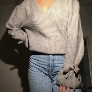 Stickad grå tröja, Linn Ahlborg NaKd-kollektion - Grå stickad tröja med knytningar vid ärmarna. Från Linn Ahlborgs kollektion för NaKd. Helt oanvänd, storlek XXS men är väldigt stor i storleken så skulle säga att den passar XS-S. Finns endast kvar på hemsidan i svart och vit, samt slutsåld i de flesta storlekar. Köparen står för frakten! Priset kan diskuteras!