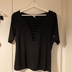 Svart t-shirt - Svart t-shirt med urringning (se bild) 