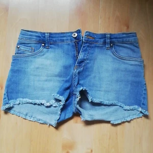 Stadium Jeans-shorts strl. 164 - Ett par jeans-shorts från Stadium märke WA. Använda 2 gånger pga. fel storlek men väldigt sköna. Har knapp, dragkedja och möjlighet till skärp, samt fickor bak och fram. Fransar ner till som gör de extra snygga. 98% Bomull och 2% Elastan. Pris + inkl. fra