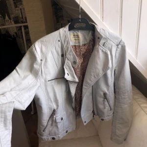 Ljus skinnjacka med fint innertyg - Ljus skinnjacka med fint innertyg. Strl L men känns som en S-M. Fint skick förutom en reva i innertyget som syns på sista bilden! Även lite skrynklig för tillfället då den legat i min garderob! Skönaste skinnjackan jag haft!! Frakt tillkommer🧚‍♀️