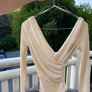 Topshop omlott body - Benvit ribbad body från topshop helt ny. Med öppen rygg och knappar under. Pris kan ändras vid snabb affär
