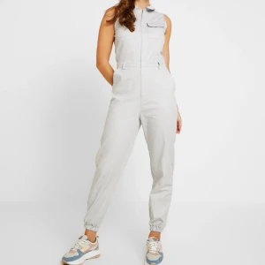 Missguided utility, cargo byxdress - Supersnygg ljusgrå byxdress från Missguided. Endast använd en gång så den är i nyskick. Storlek 38. Slutsåld på hemsidan. Material: 100% bomull