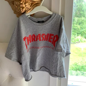 Trasher crop top storlek XS - En jättegullig crop top från Trasher, köpt här på Plick för ca 1 år sedan. Henne jag köpte den från hade croppat den själv jättesnyggt. Lite skater vibes över den 🛹✨ Den är som ny, har knappt använt den.