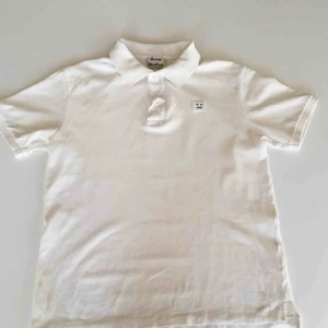  - Acne Studios piké med smileyikon på bröstet.