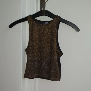  - Crop-top från H&M. Den är dovt guldglittrig på framsidan och svart på baksidan. Använd 2 gånger.