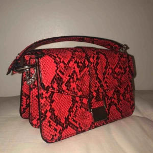  - Sjukt snygg väska från zara me ormprint i rött o svart.      Har två fack o ett silvrigt spänna men knäpper för o stänga på framsidan. Säljer pågrund av att den inte kommer till användning💗💗