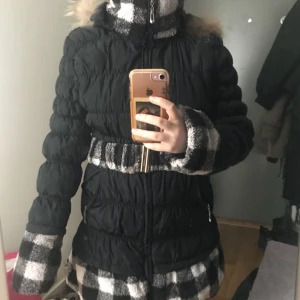  - Svart cool och fin vinter jacka med päls rund armarna och med en päls bälte som går runt midjan 