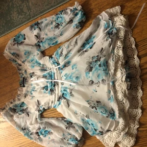  - Vit klänning med blå blommor, spets och rosett