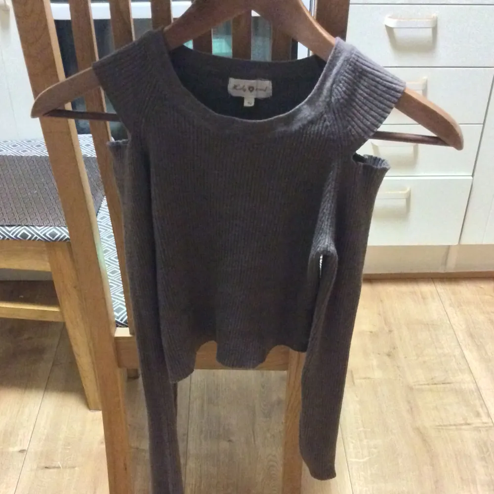 En midjekort brun tröja med hål/ bart om axlarna, sitter jätte snyggt på och är i storlek XS/S.. Tröjor & Koftor.