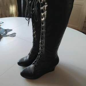 Skitsnygga kilklacksstövlar med korsettsnörning 40 - Strl 40 men liten i storleken. Av sparsamt använda. Dragkedja på sidan. Högt skaft