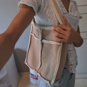 Mjuk Axelväska i Mocca-imitation - En mycket mjuk o len axelväska i mocca-imitaion med flis inuti.  Man stänger det med en magnet-knapp. Är ungefär 30x40cm och ca 5-7cm i bredd. Pm för exakta mått och frågor. 