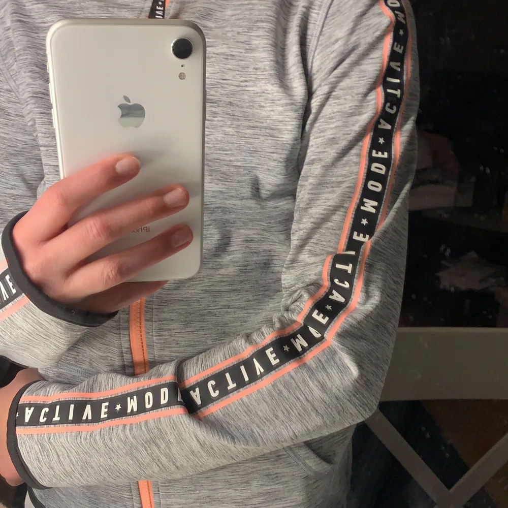 Här är en tränings långärmade tröja! Det står en text på armen och de är en orange dragkedja🥰. Hoodies.