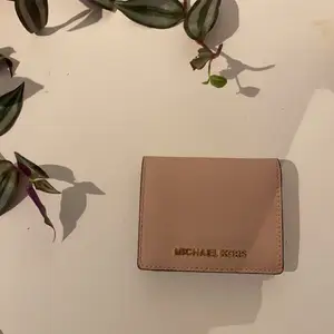 Jättefin äkta Michael kors plånbok! Den är i perfekt skick då den används väldigt lite varför jag också säljer den. Praktisk, rymmer väldigt många kort och kontanter! Den är jättefin färg rosa/beige. Köppte den för runt 6/700 kronor tror jag. 💕Men högsta bud får den!💕 minst 200kr  