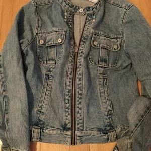 Snygg jeansjacka i bikermodell med nitar strl 42 - Sparsamt använd. Djur och rökfritt hem. Från Lindex. Strl 42. Samfraktar gärna!