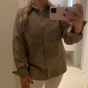 Brun/beige skjorta  - Fin skjorta i trendig brun färg perfekt till hösten! Den är aldrig använd och i nyköpt skick!💕💕 Passar 34-36! Frakt tillkommer