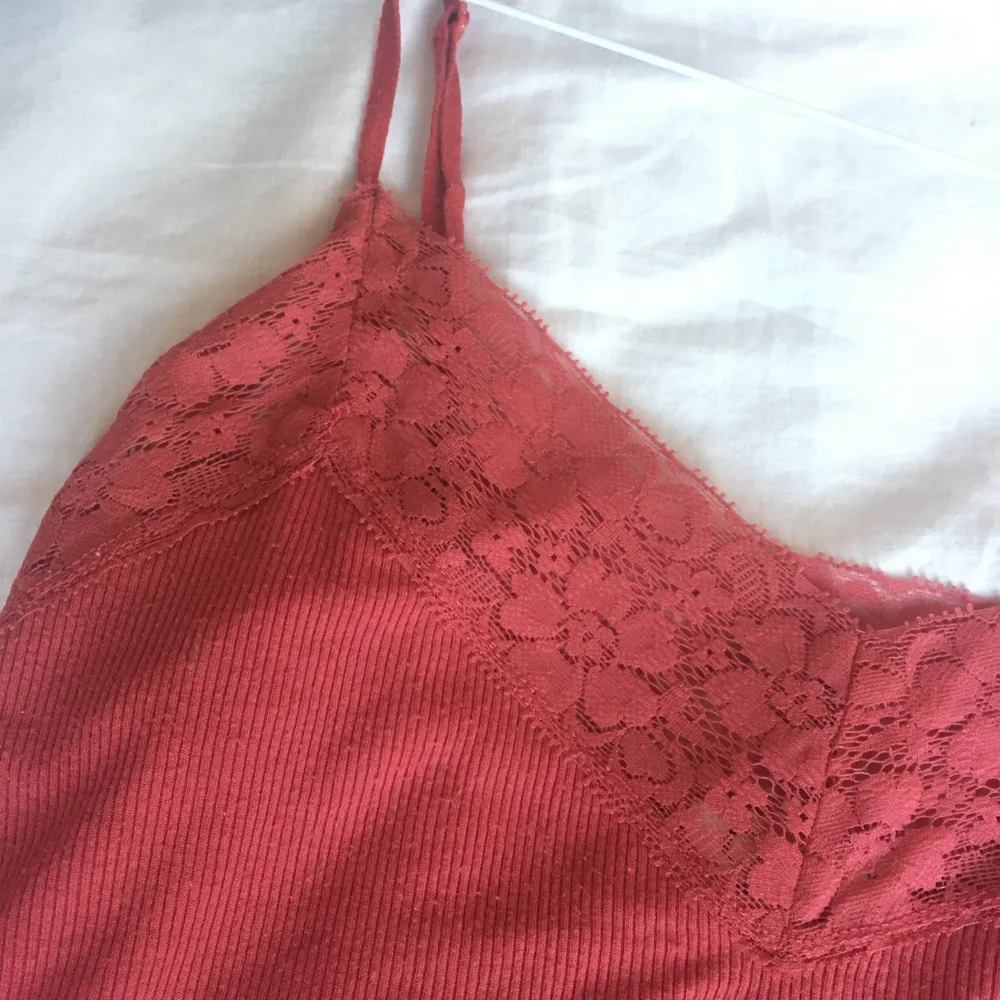 Ett jättefint rött/rosarött linne med spets runt kragen i XS! Pris: 40kr. Toppar.