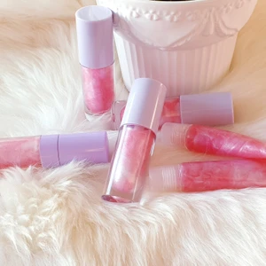 PEARL LIPGLOSS 🧜‍♀️ - Pearl läppglans är ett shimmer rosa med jordgubb smak/doft.  Innehåller cocosolja, E vitamin, sweet almond olja. Den hjälp att återfuktar och mjuk göra läpparna. Speciellt i den här kalla väder. Finns i squeeze tuber - 25kr, tjocka lila wand tuber- 40kr, långa lila wand tuber- 50kr. FRAKT 15KR. 