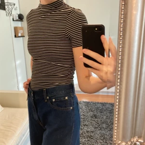 Randig t-shirt - Svart och vit randig t-shirt från h&m med hög hals. Använd ett par gånger men fortfarande i bra skick!