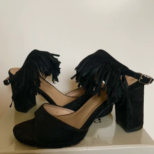 Svarta heels med fransar -  använda en del, syns i hålen där man spänner men fortfarande användbara! Klack: 9cm FRAKT TILLKOMMER (KOLLA BIO)