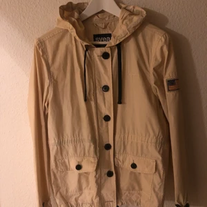 Jacka - Beige jacka med dragkedja, knappt och luva från Svea. Storlek S. Fint skick. Köparen står för frakt.