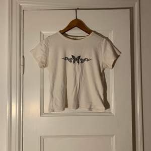 Jätteskön T-shirt från Brandy Melville med tryck av en fjäril och tribal på bröstet! Passformen och materialet är väldigt nice :) strl S 