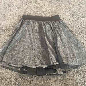  - En glittrig kjol.Aldrig använd typ och passar till 12-15 typ