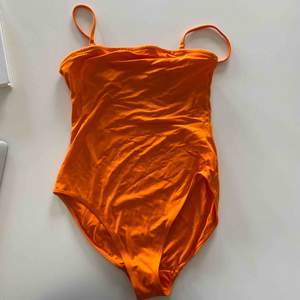 Orange baddräkt från monki! Oanvänd och endast provad :) frakt ingår. Man kan även ta av axelbanden så man får en strapless baddräkt! 🧡