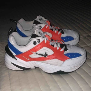  - NIKE MK2 Techno i storlek 38. Använda med lite defekter, hänvisar till bild 3. Mycket sköna! Snygg röd/vit/svart/blå färgkombo. Köpta för 999kr. Möts upp i Stockholm/fraktar (köparen står för frakten).