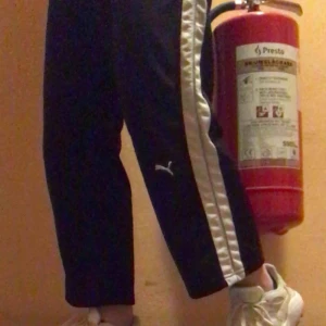  - Pumabyxor köpta på Beyond Retro. Lite flare, vit rand på sidan med en liten ljusblå rand i och så puman på vänstra benet. Har inget resår, dras åt med snöre i midjan. Skriv för fler bilder för domhär bilderna suger