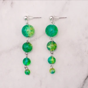 Örhängen med glaspärlor  - Unika silverfärgade örhängen med tvåfärgade glaspärlor i olika storlekar. Nickelfria. Frakt 11:-, fri frakt vid köp över 100:-. 