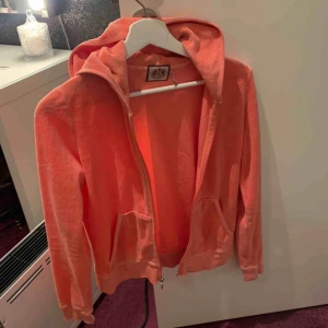 Juciy couture - En orange/ljusrosa juicy couture huvtröja. I befintligt skick. Passar en xs till m. Finns byxor till för samma pris. För hela sättet blir det 450 Köparen står för eventuell frakt