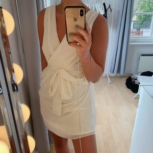 Vit klänning - Säljer nu denna vita klänning med knyte. Passar jättebra till både skolavslutning & som en vanlig sommarklänning. Finns inga skador eller liknande. Bandet går knyta både framåt & bakåt. Frakt tillkommer