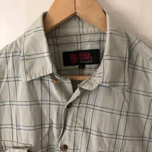 Fjällräven kånken shirt in colors beige and slightly striped with white and grey in size L. In perfect condition.
