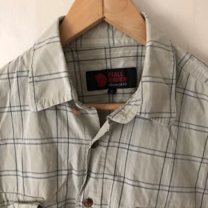 Fjällräven  - Fjällräven kånken shirt in colors beige and slightly striped with white and grey in size L. In perfect condition.