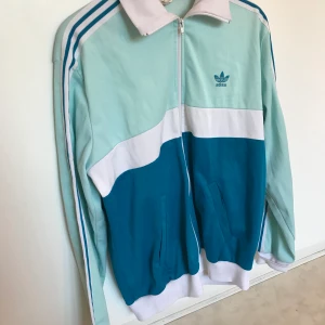 retro adidas original track top - fin track top från adidas original i bra begagnat skick. jackan andas 80-tal i olika blå/turkosa nyanser. oklar storlek (har suddats ut på lappen) men gissningsvis L/XL. hämtas i malmö eller skickas med posten. se även mina andra annonser för ev samfrakt.
