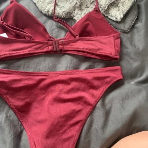 Bikbok bikini - Vinröd bikini från Bikbok, superfin med söta detaljer på höfterna och mellan brösten, Xs men passar även S, lite mörkare röd i verkligheten, knappt använd