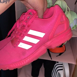 Zx Flux Adidas - Använt dessa ett par gånger, går att tvätta för att få bort smutsfläckar. Köpt ifrån Zalando. Dom är inte trasiga nånstans och väldigt fin rosa färg. Eftersom dom är så pass fina så vill jag ha en bra peng för dessa. 