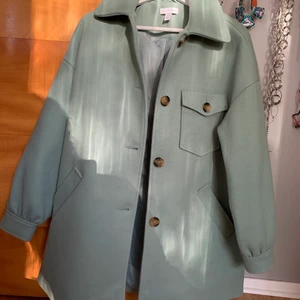 Grön Ulljacka strl M  - Grönblå jacka i mestadels ull från Nelly (Topshop) strl M - använd ca 5 ggr, säljes pga lite stor! Kan mötas runt Sthlm innerstad/söder ut annars står du för frakt :)