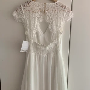 Chiara Fhorti Empress Dress - Jättefin vit klänning, perfekt till studenten. Helt oanvänd, sitter jättefint, säljer eftersom jag hittat en annan som jag gillar mer! 66kr för frakt! Originalpris 499kr