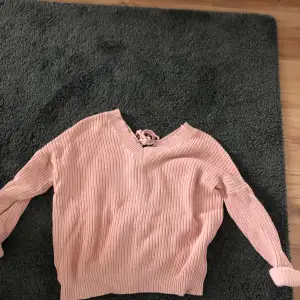 En rosa tröja från nelly med en knytning vid ryggen. 