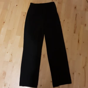  - Snygga högmidjade festbrallor i kostym material. De är utsvängda och bra i längden på mig som är ca 160 cm. Det tillkommer ett frakpris på 50 kr!