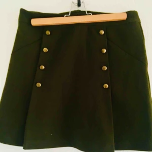 - Grön kjol med knappar framtill, knappt använd, lätt utsvängd nertill 