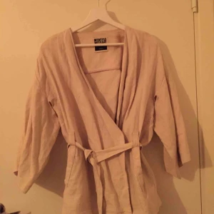  - Naturvit kimono i 100% linne från Weekday. Nyskick.  Möts upp i Stockholm efter överenskommelse alternativt skickas mot fraktkostnad.