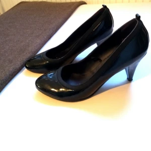  - Svarta skinande pumps.