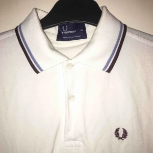  - Vit Fred Perry pike. Storleken är XS man och funkar bra för tjej mellan xs-m gissar jag!  Möts i Hornstull eller fraktar :)