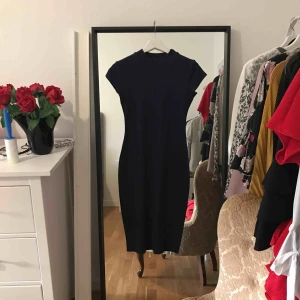  - Marinblå ribbad långklänning. 