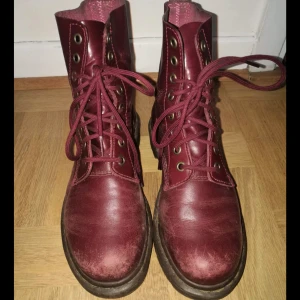  - Höga kängor från Dr Martens, vinröda i storlek 37. I mycket fint skick, lite slitningar vid tårna.